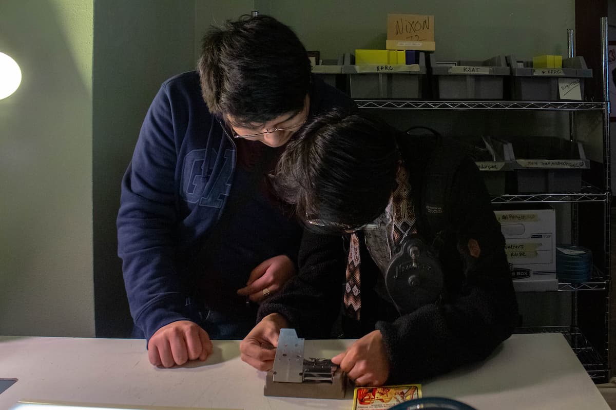 Students in the Media Arts program cutting Super 8 film.
